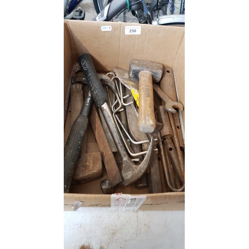 250 - A mixed lot of hand tools including pick axe, sledge hammer, large metal bar, hammers, chisels, etc.