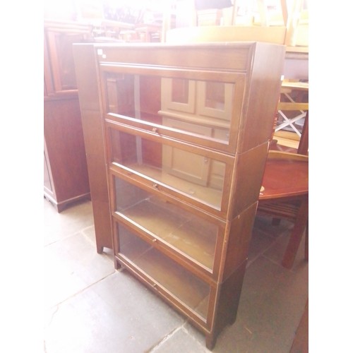 921 - An oak sectional bookcase by 'GUNN'.