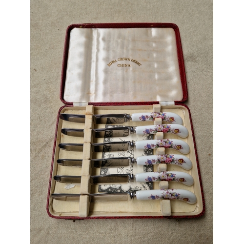 989 - A set of 6 Royal Crown Derby knives with ceramic handles, in original case.