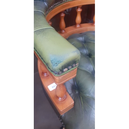 891 - A green leather Chesterfield captain's chair.