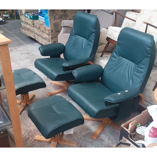 770 - A pair of green faux leather swivel chairs with stools.