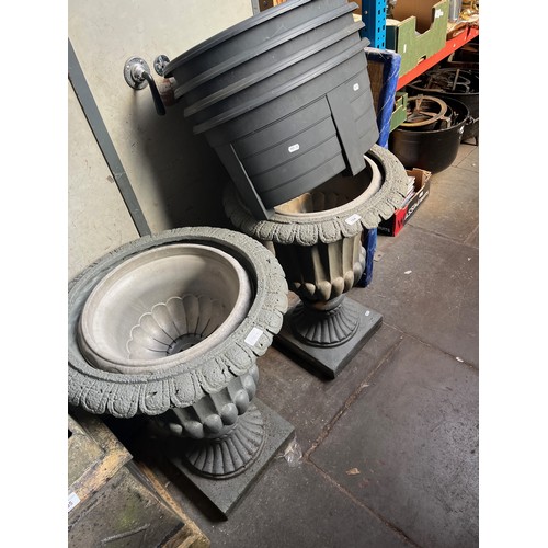 104 - Pair of composition urns and plastic plant pots.