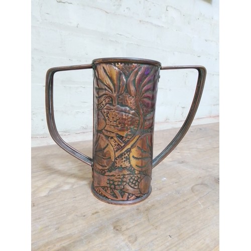 149 - An Arts & Crafts copper twin handled vase, designed by John Williams with hammered decoration depict... 