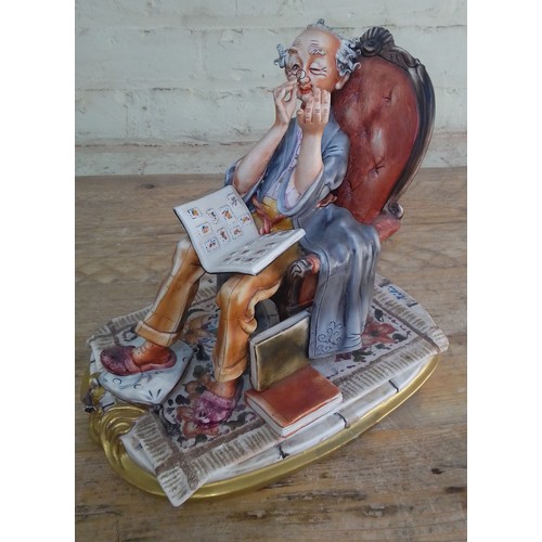 269 - A Capodimonte figure 'The Philatelist', signed Milio, length 27cm.