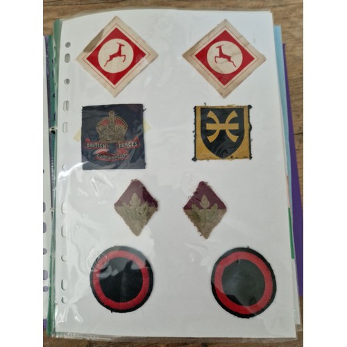 142 - Three albums of military badges, patches and buttons.