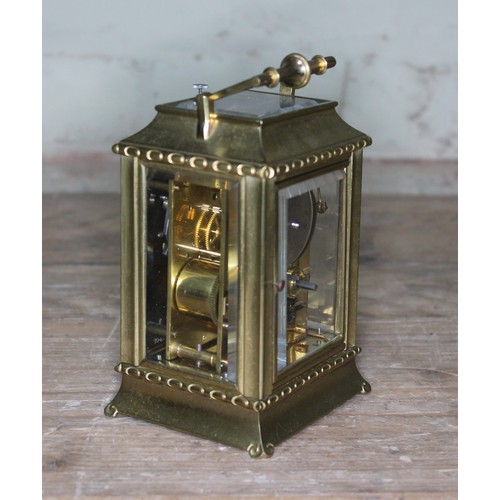 106 - A late 19th century brass repeat carriage clock, etched brass with round enamel dial having Roman nu... 