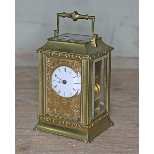 106 - A late 19th century brass repeat carriage clock, etched brass with round enamel dial having Roman nu... 