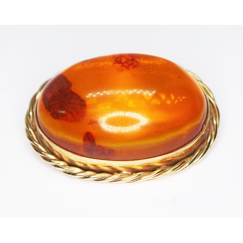 65 - A 9ct gold mounted amber cabochon brooch, rope twist border, sponsor 'G.M', Sheffield 1994, length 3... 