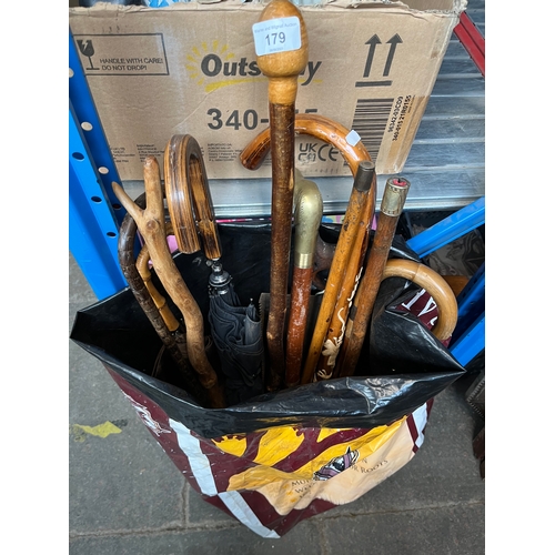 179 - Various walking sticks, umbrellas and two wood saws