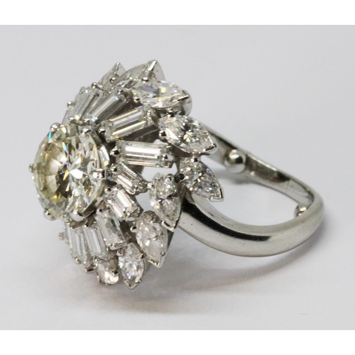 9 - A diamond cluster ring in the manner of Boucheron, circa 1960s, the principal round brilliant cut di... 