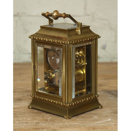 106 - A late 19th century brass repeat carriage clock, etched brass with round enamel dial having Roman nu... 