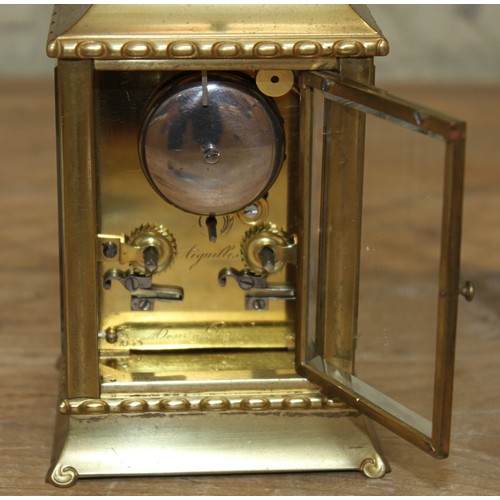 106 - A late 19th century brass repeat carriage clock, etched brass with round enamel dial having Roman nu... 