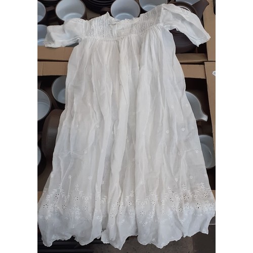 394 - A box of christening gowns and linen.