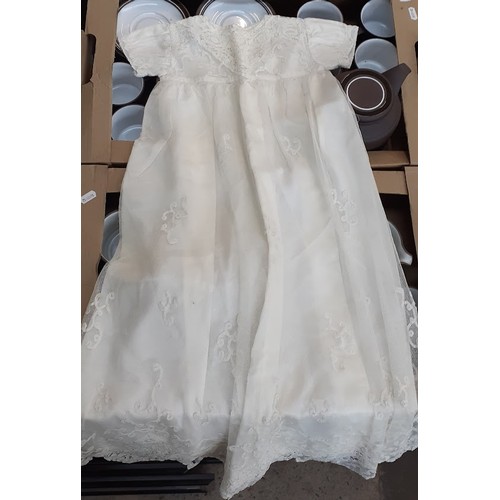 394 - A box of christening gowns and linen.