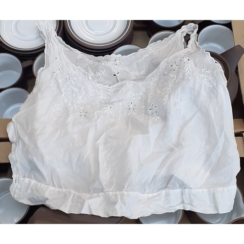 394 - A box of christening gowns and linen.