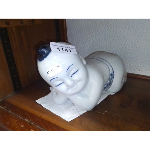 1141 - An Eastern ceramic figure of a young Buddha, with receipt from Singapore.