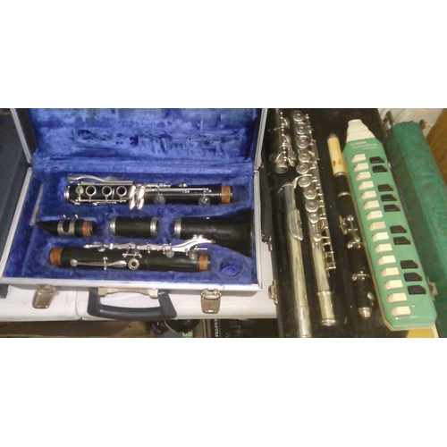 243 - Assorted musical instruments comprising a clarinet, a silver plated flute, a rosewood piccolo and a ... 