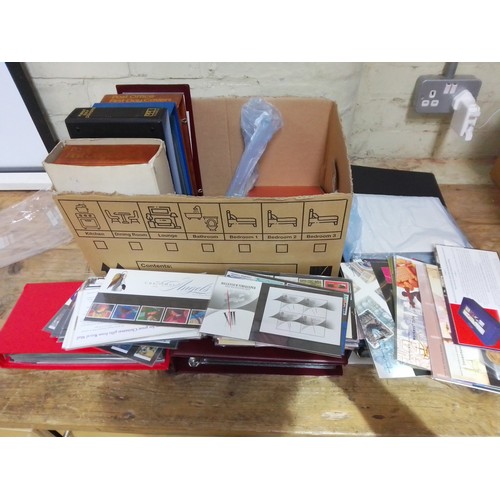 305 - A box of stamps including folders of first day covers, mint stamp set, post office advertising poste... 