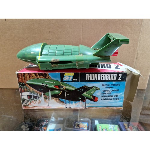 327 - A box of vintage toys including AJR 21 Thunderbird toys.