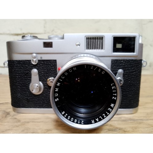 178 - A Leica M2 35mm camera, circa 1963, serial no. 1086329, with Summicron 1:2/50 lens and leather case.