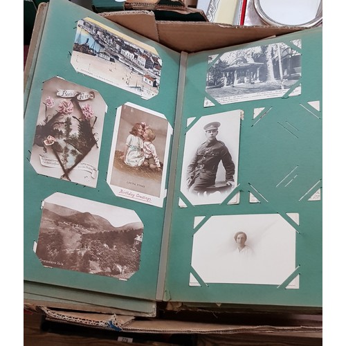 272 - A box of early 20th century postcards albums.