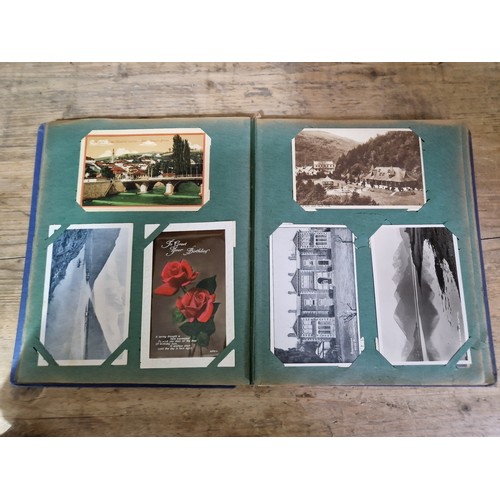 272 - A box of early 20th century postcards albums.