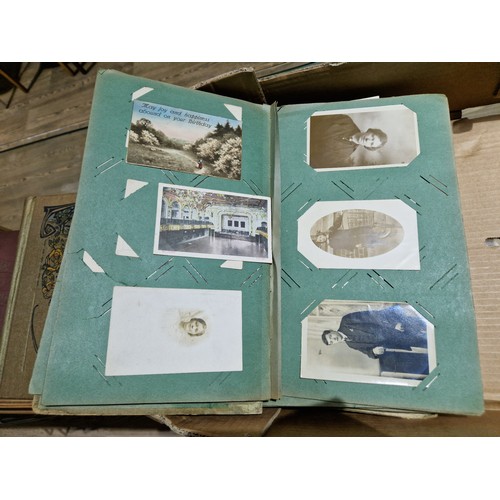 272 - A box of early 20th century postcards albums.