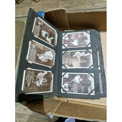 272 - A box of early 20th century postcards albums.