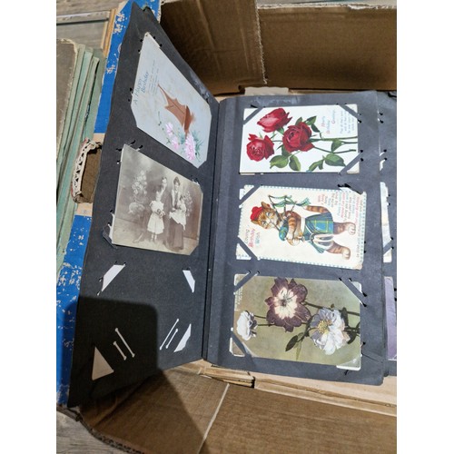 272 - A box of early 20th century postcards albums.