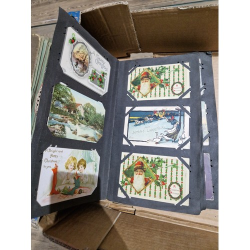 272 - A box of early 20th century postcards albums.