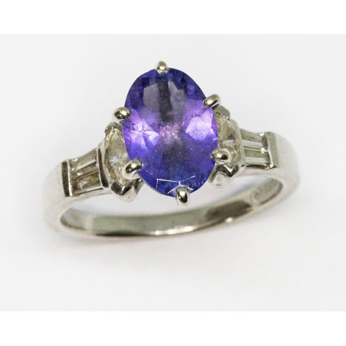 31 - A tanzanite and diamond ring, the oval cut tanzanite weighing approx. 2.30cts, marquis and baguette ... 