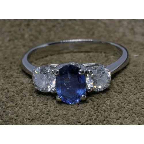 75 - A diamond and sapphire ring, the central oval stone weighing approx. 1ct, flanked by round cut diamo... 