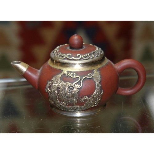 159 - A Chinese white metal mounted miniature Yixing red clay teapot and cover, seal mark to base, length ... 