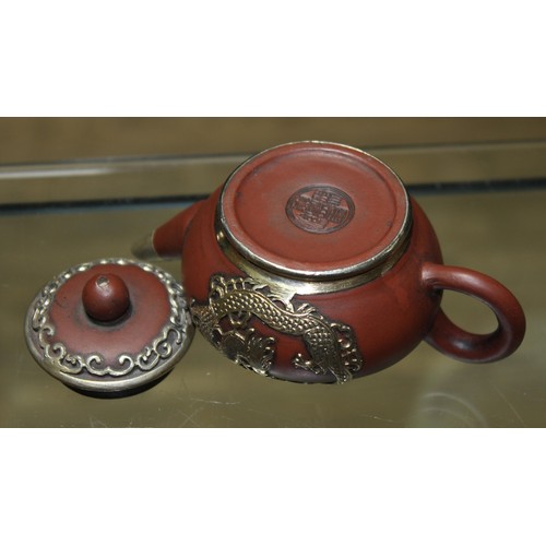 159 - A Chinese white metal mounted miniature Yixing red clay teapot and cover, seal mark to base, length ... 