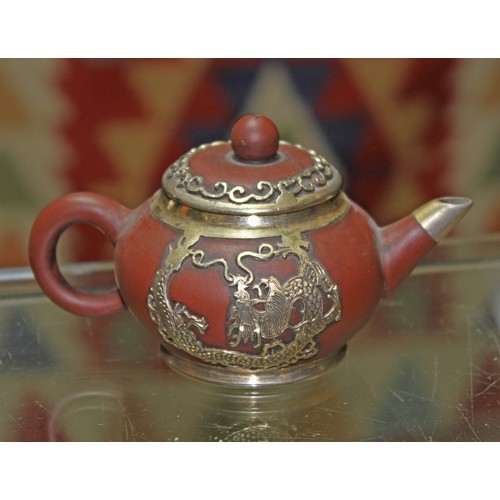 159 - A Chinese white metal mounted miniature Yixing red clay teapot and cover, seal mark to base, length ... 