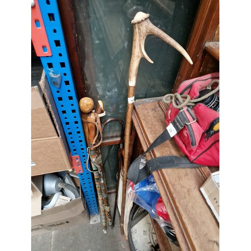 103 - A bundle of walking sticks, and a vintage umbrella, one stick with a silver tipped handle