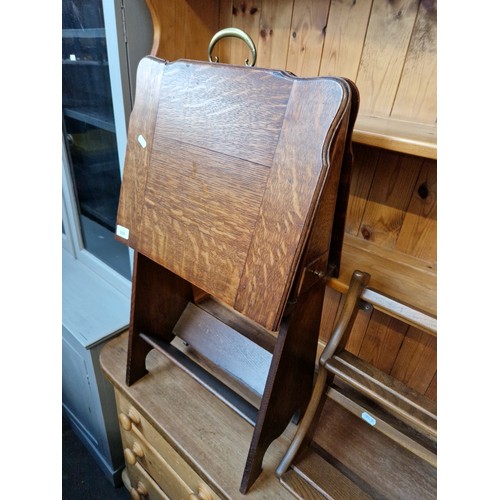 958 - An early 20th century oak magazine table with slide out pipe rack containing a number of pipes to th... 