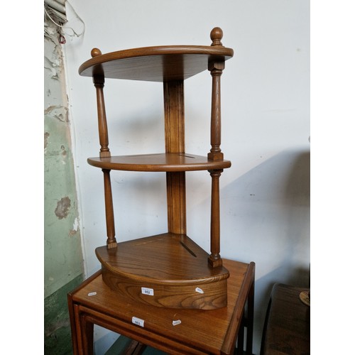 952 - An Ercol elm three tier corner stand.