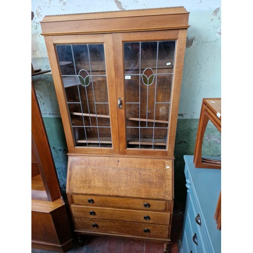 954 - An early 20th century oak and leaded glass bureau bookcase.