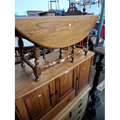 963 - An Ercol elm side cabinet/TV stand together with an Ercol drop leaf coffee table.