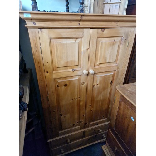 961 - A waxed pine double wardrobe with drawers to base.