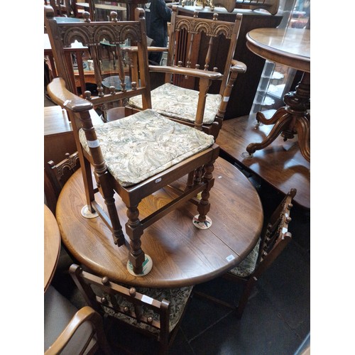 983 - An Ercol elm extending dining table and six chairs including two carvers.