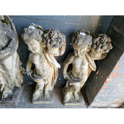 251 - A pair of concrete garden ornaments - children carrying bunches of grapes