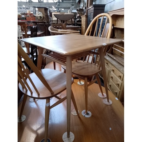 979 - A mid 20th century Ercol light elm breakfast table (model 395) together with two Ercol 'Quaker' chai... 