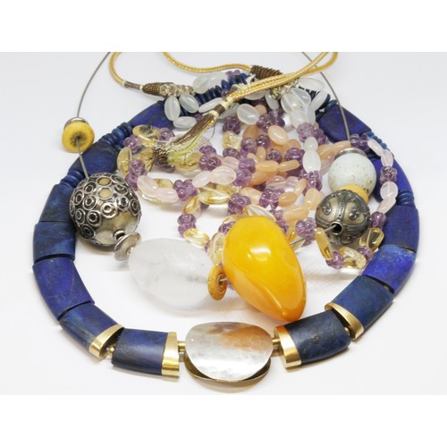 181 - Three modern necklaces comprising one formed from lapis lazuli slabs and beads with a hammered gilt ... 