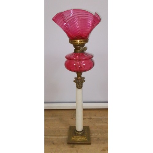438 - A Victorian cranberry glass oil lamp, ribbed shade, Duplex fitting, cranberry reservoir, Corinthian ... 