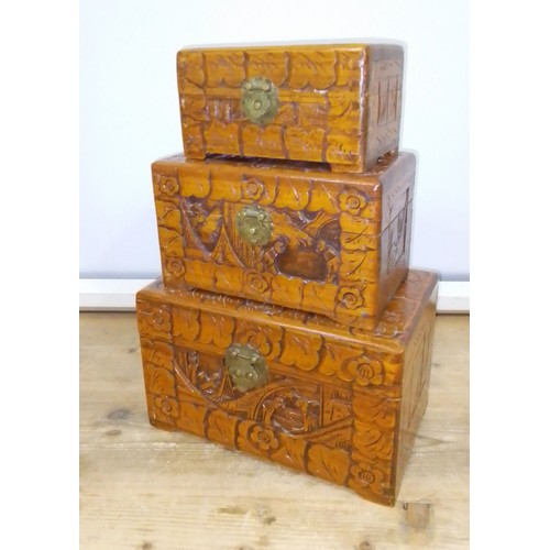 448 - A set of three graduated Eastern carved camphor wood boxes.