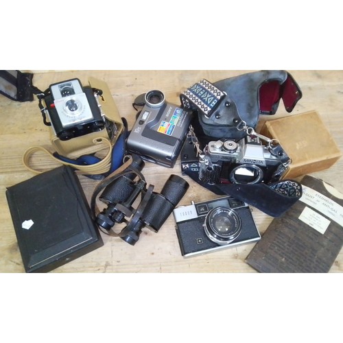 477 - A mixed lot comprising cameras, a box of slides, a pair of binoculars and military eyeshields.