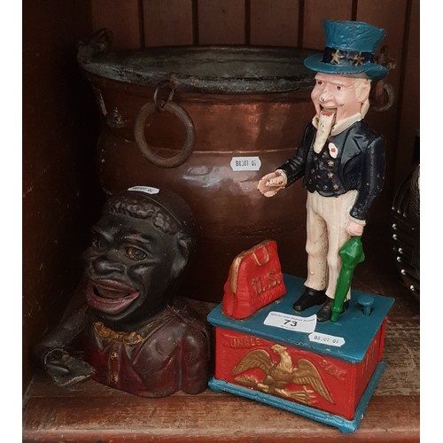 73 - A mixed lot of metal ware comprising two novelty cast metal money banks and a copper bucket.