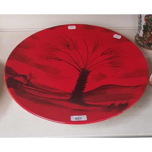 627 - A Peggy Davis Ceramics red glazed charger decorated with palm tree, original artists proof.